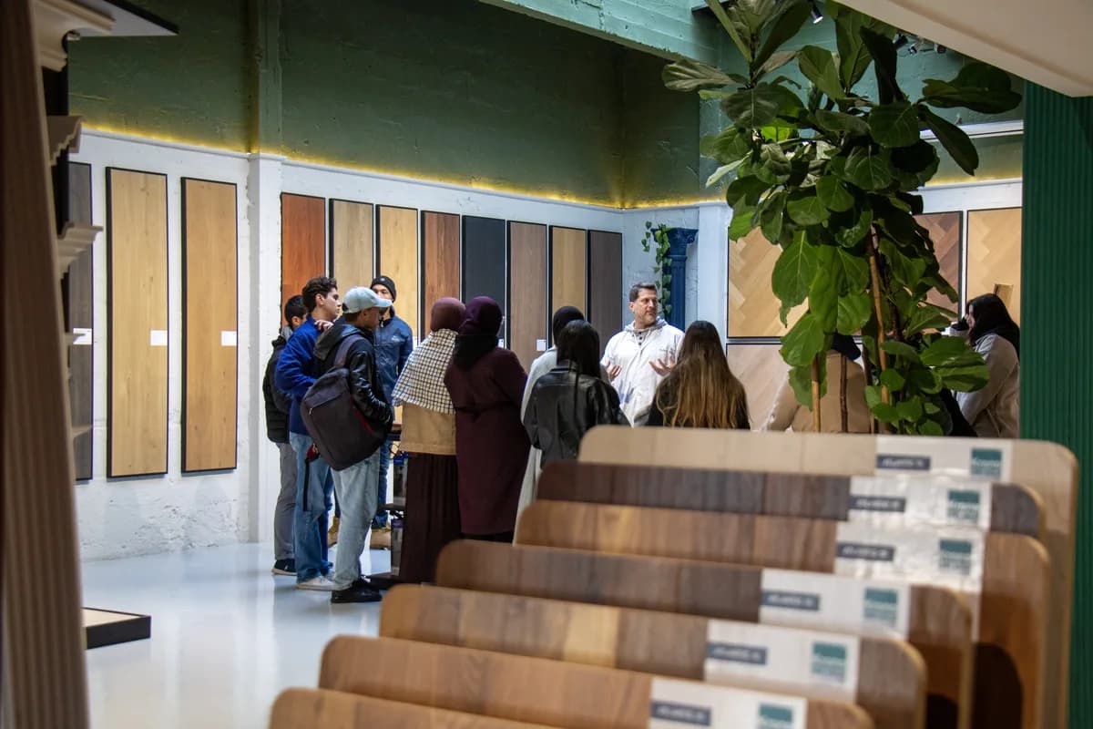 Des visiteurs devant les présentoirs d’échantillons dans un showroom Worqbox.
