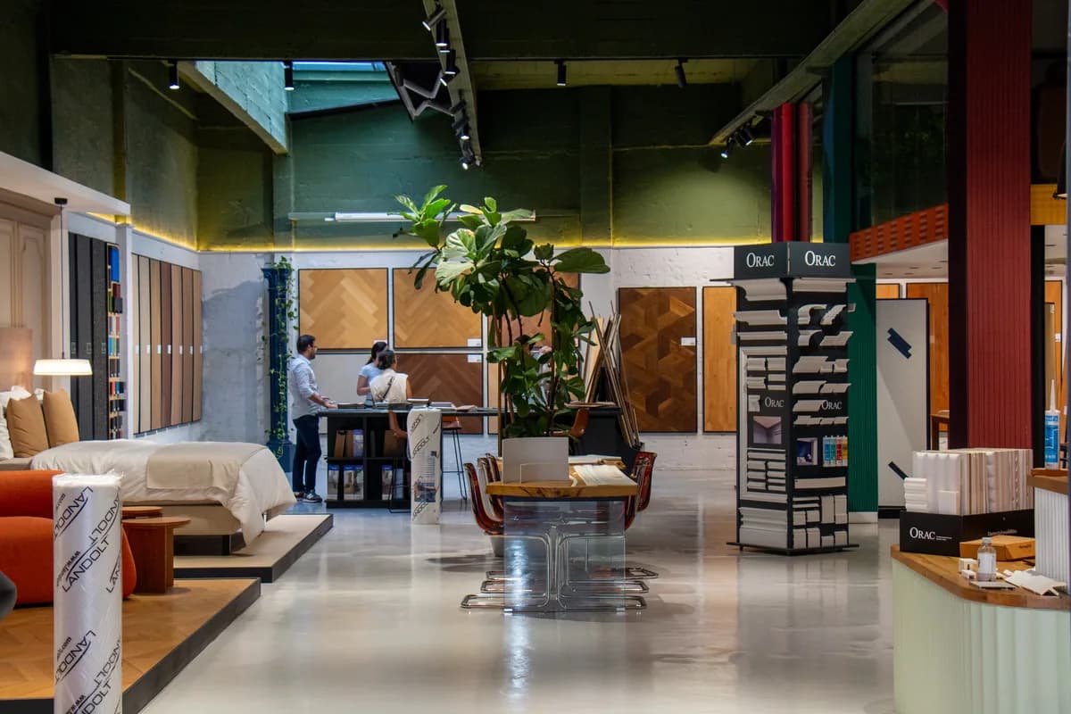 L’espace d’exposition d’un showroom Worqbox : mobilier, plantes, parquets au mur et présentoir Orac.
